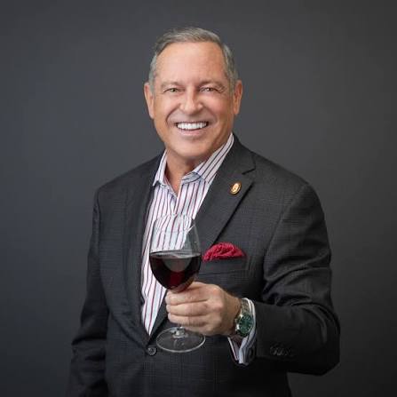 Master Sommelier Peter Neptune holding a glass of red wine